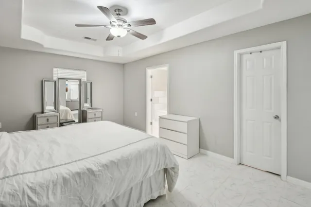 a spacious bedroom with a bed and a ceiling fan