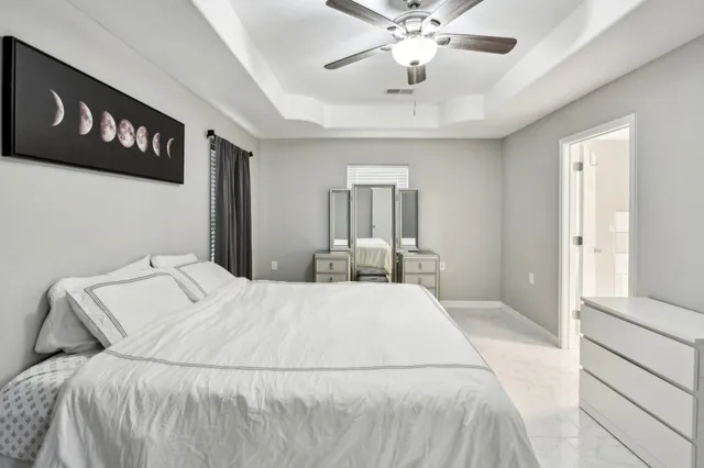 a bedroom with a large bed and a chandelier