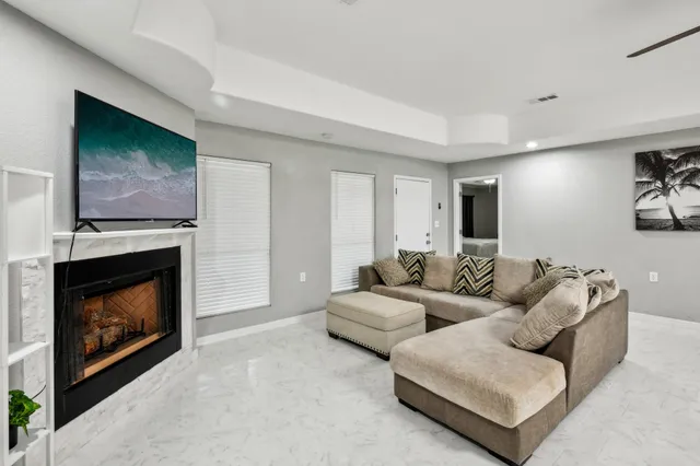 a living room with furniture kitchen view and a chandelier
