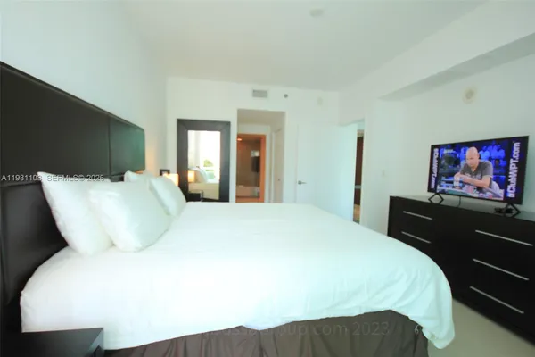 a large bed sitting in a bedroom next to a window