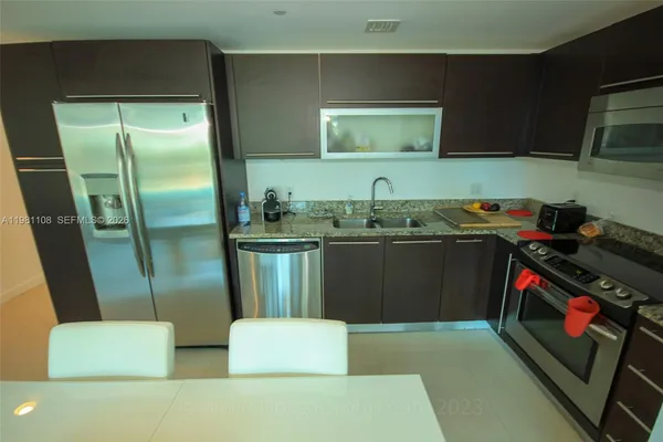 a kitchen with a sink a refrigerator and washer
