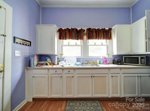 a kitchen with granite countertop a stove a sink and a microwave