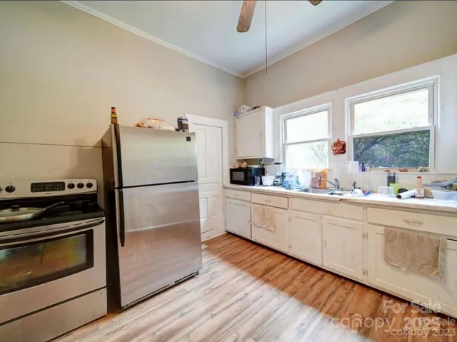 a kitchen with granite countertop a refrigerator stove and sink