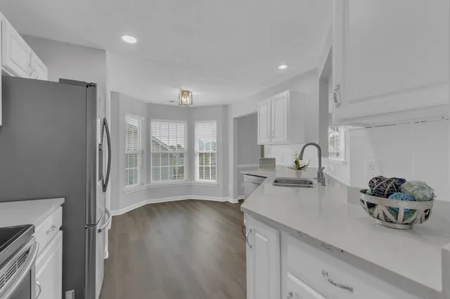 a kitchen with stainless steel appliances a sink a window and wooden floor