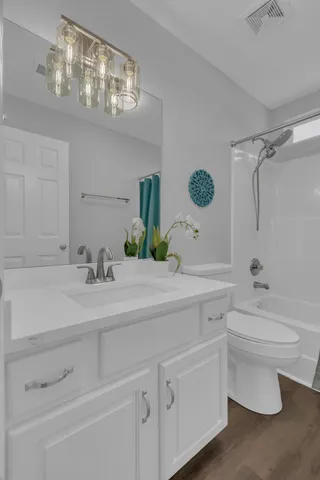 a bathroom with a sink vanity granite toilet and a mirror