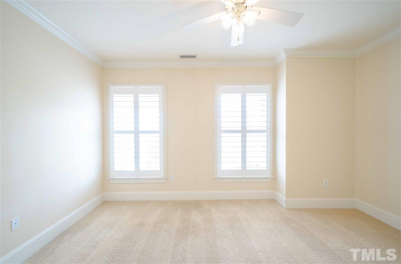 710 Independence Place, Unit 407 Raleigh, NC 27603 - Photo 19 of 27 an empty room with windows and chandelier fan