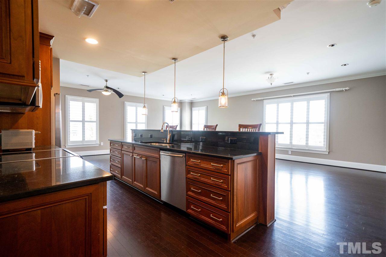 710 Independence Place, Unit 407 Raleigh, NC 27603 - Photo 3 of 27 a kitchen with stainless steel appliances granite countertop a stove a sink and a refrigerator