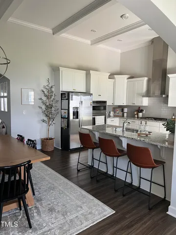 a living room with stainless steel appliances kitchen island granite countertop furniture and wooden floor