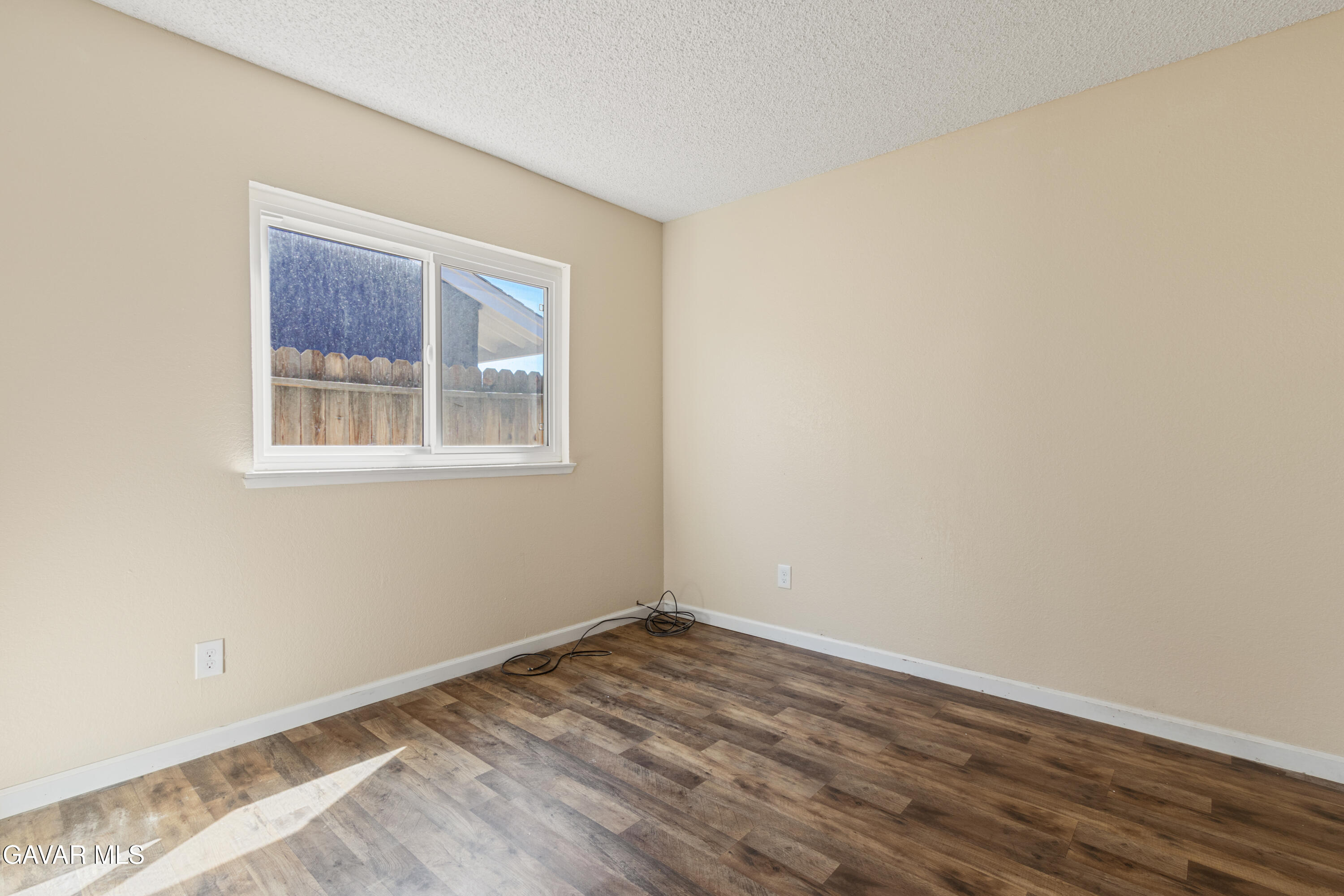 2128 Edam Street Lancaster, CA 93536 - Photo 18 of 26 a view of an empty room with wooden floor and a window