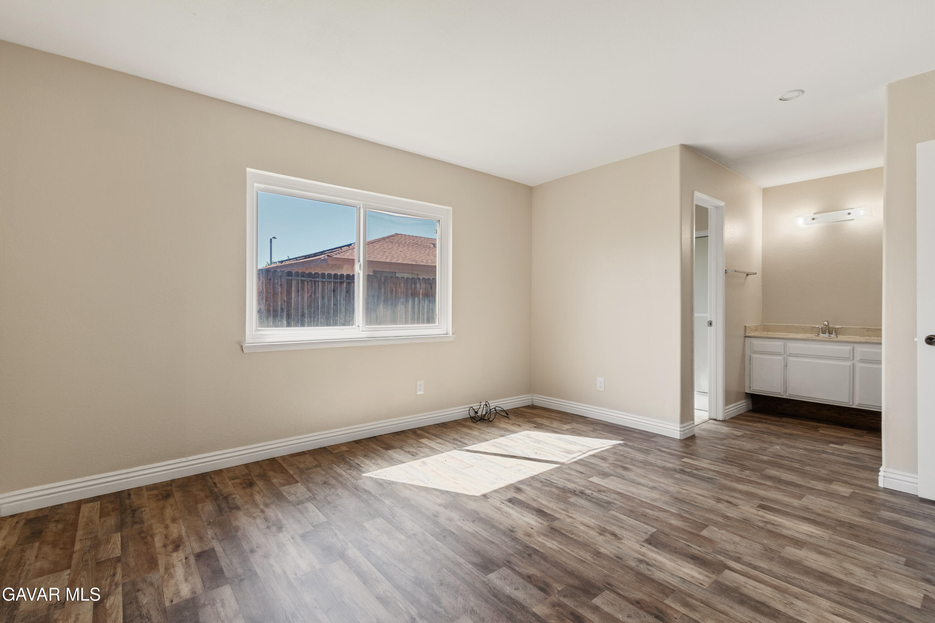 2128 Edam Street Lancaster, CA 93536 - Photo 21 of 26 a view of an empty room with wooden floor and a window