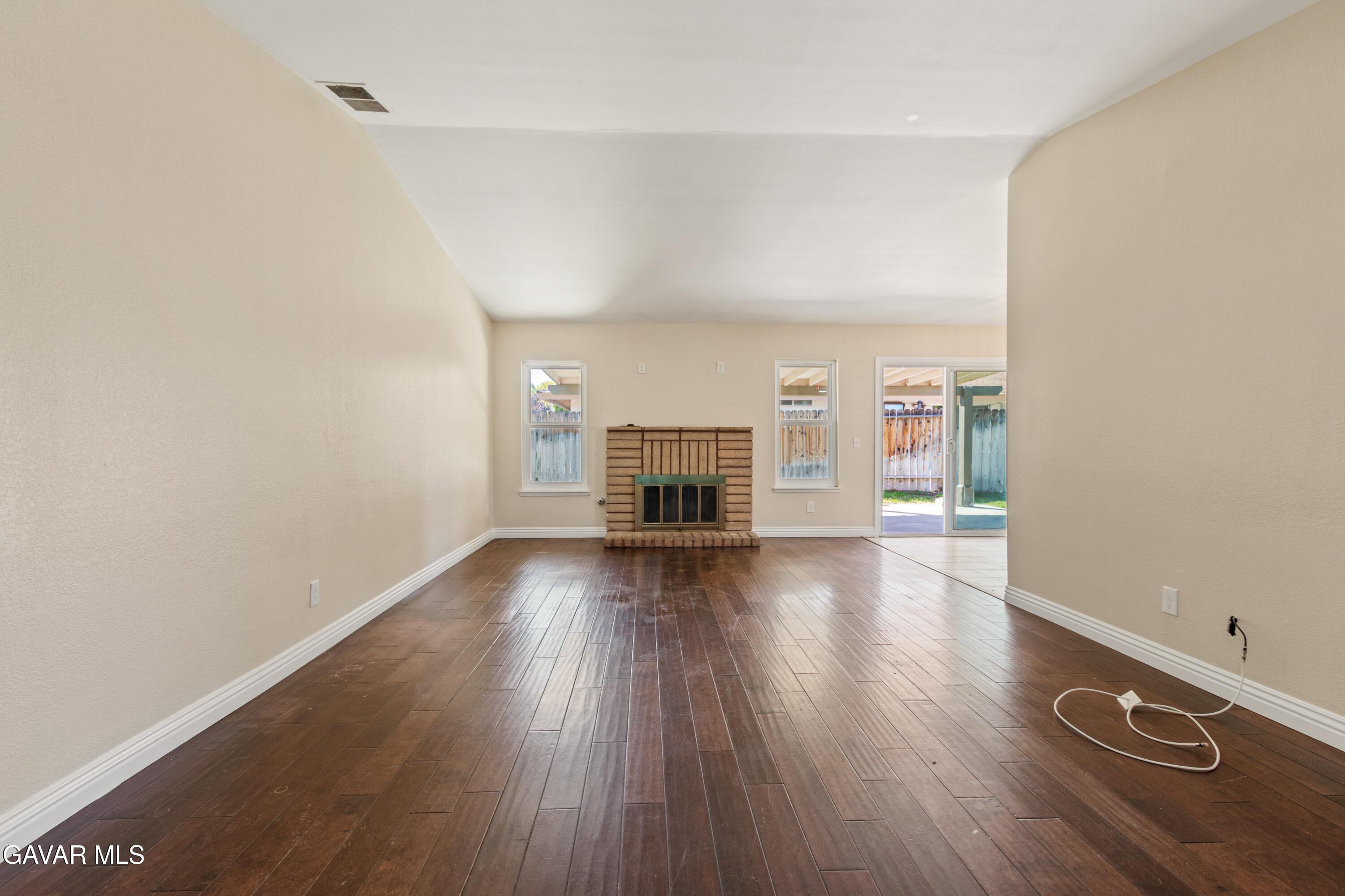 2128 Edam Street Lancaster, CA 93536 - Photo 3 of 26 an empty room with wooden floor fireplace and windows