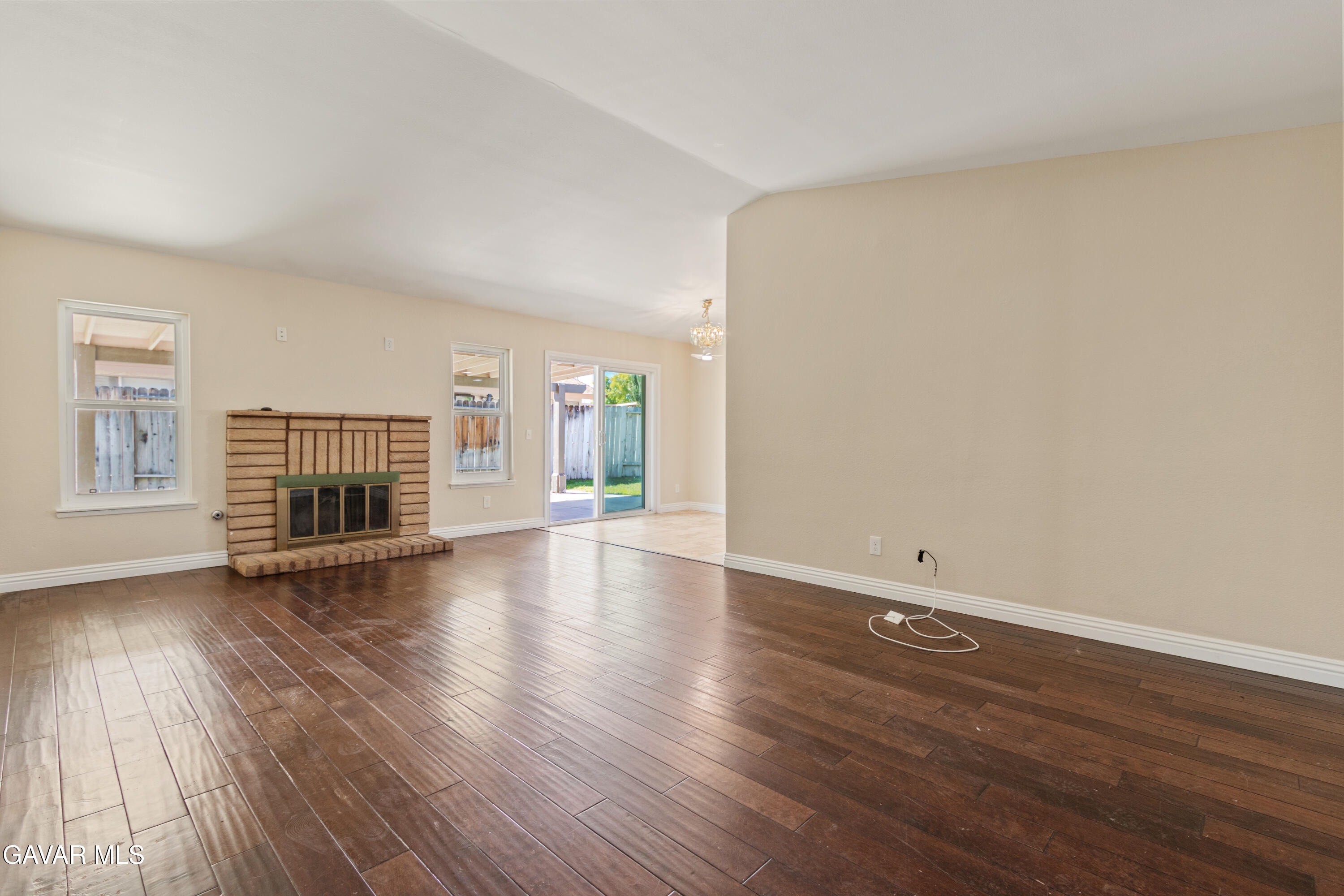 2128 Edam Street Lancaster, CA 93536 - Photo 4 of 26 an empty room with wooden floor fireplace and windows