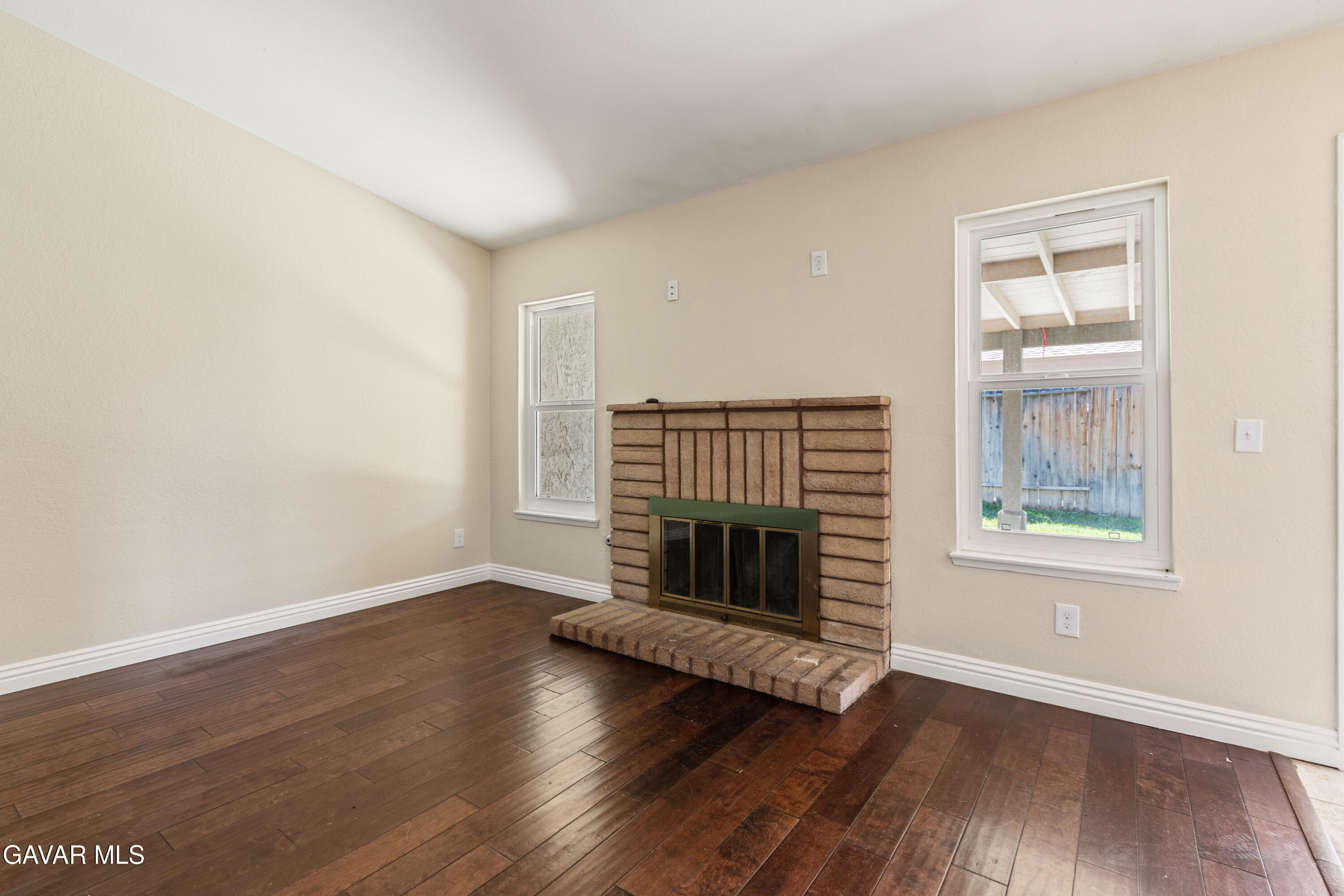 2128 Edam Street Lancaster, CA 93536 - Photo 5 of 26 an empty room with wooden floor fireplace and windows