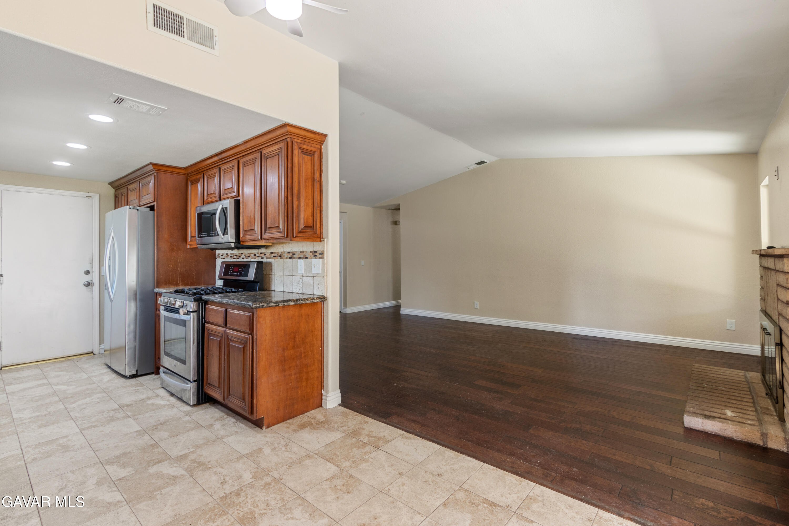 2128 Edam Street Lancaster, CA 93536 - Photo 8 of 26 a kitchen with stainless steel appliances granite countertop a stove top oven a sink and a refrigerator