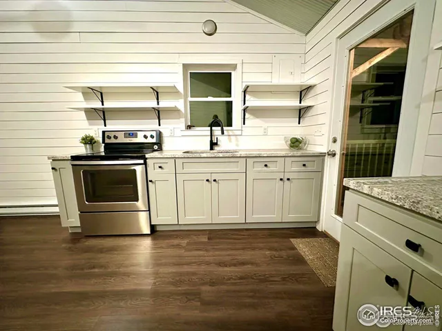 a living room with furniture and kitchen view