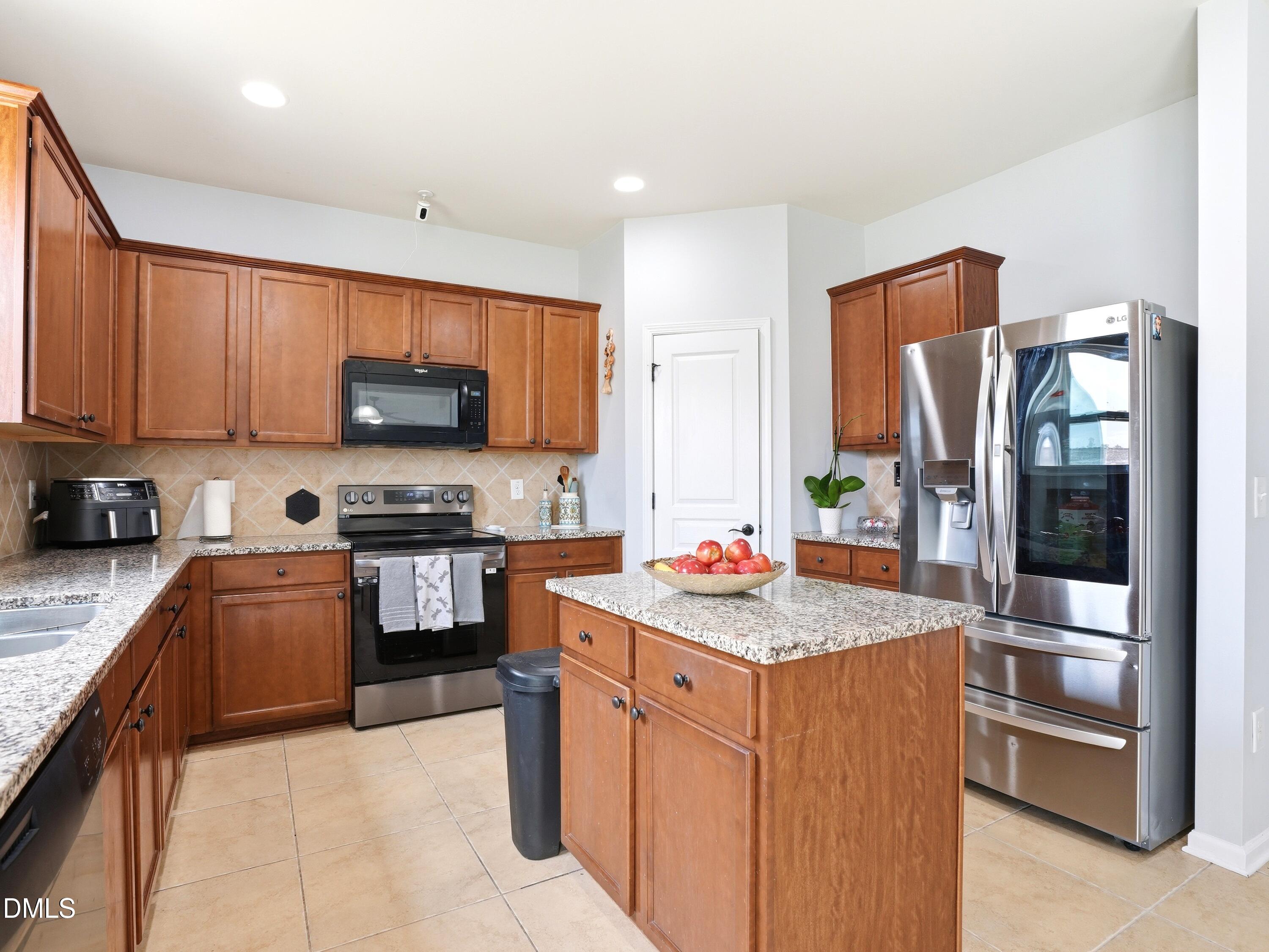 8128 Hovingham Way Raleigh, NC 27616 - Photo 9 of 40 a kitchen with stainless steel appliances granite countertop a refrigerator stove and sink