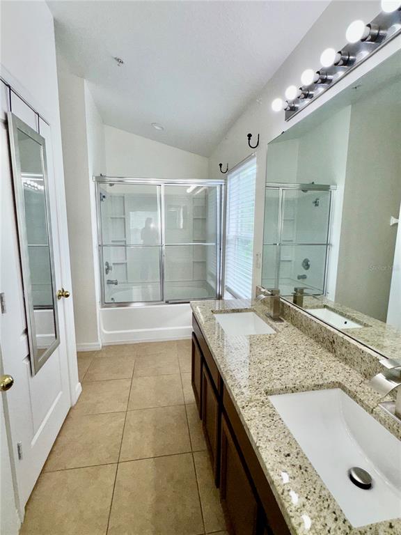 6404 South Goldenrod Road, Unit 2A Orlando, FL 32822 - Photo 27 of 40 a bathroom with a granite countertop tub sink and mirror