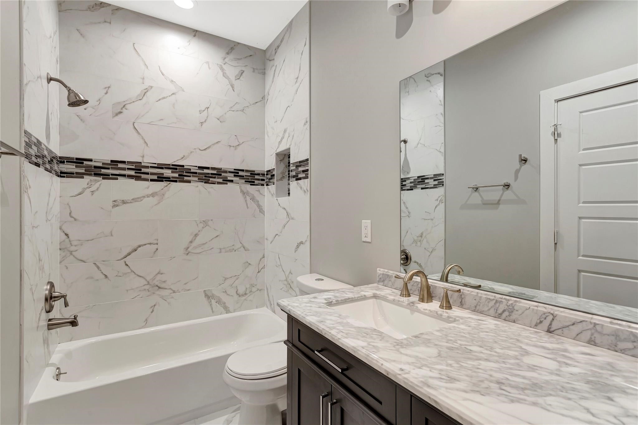 6813 Liverpool Street, Unit B Houston, TX 77021 - Photo 8 of 9 Full tub/shower with marble-look tile, mosaic accent border, espresso vanity, and marble countertop.