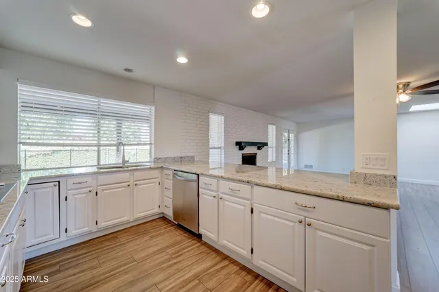 a kitchen with granite countertop white cabinets and white appliances