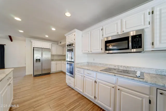 a kitchen with stainless steel appliances granite countertop a refrigerator sink and microwave
