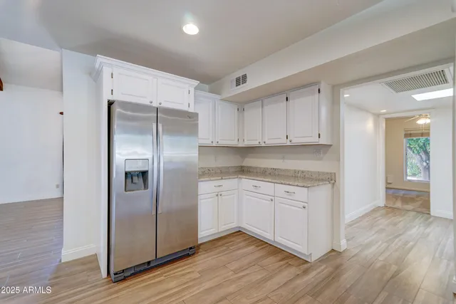 a kitchen with stainless steel appliances granite countertop a refrigerator and a stove top oven