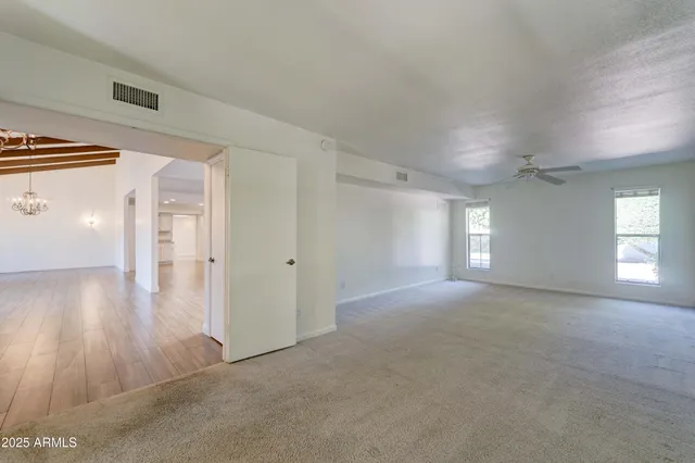 a view of a big room with wooden floor and windows