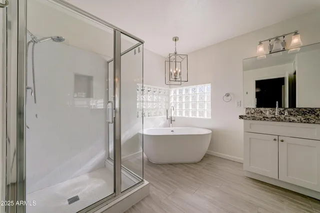 a bathroom with a tub sink shower and mirror