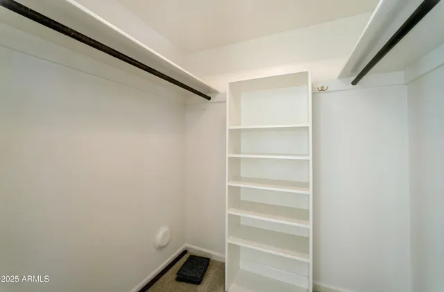 a view of walk in closet with empty racks