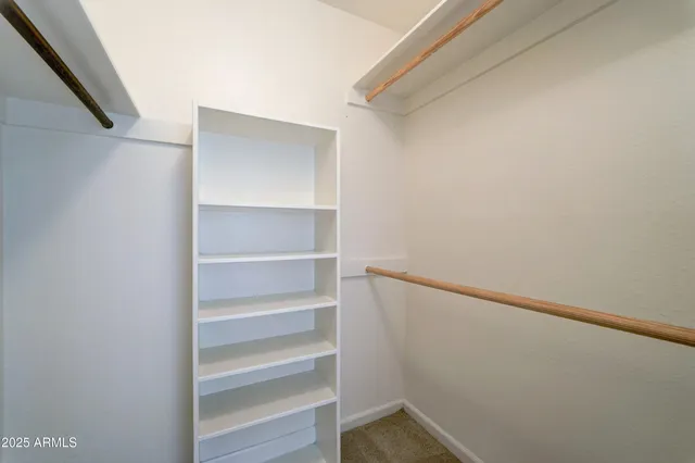 a view of walk in closet with empty racks