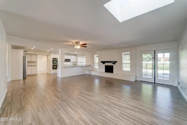 a view of empty room with wooden floor and fireplace