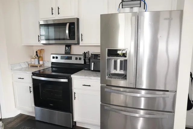 a kitchen with stainless steel appliances a refrigerator stove and microwave