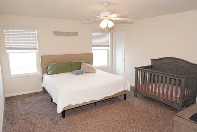 a bedroom with a bed window and a chandelier