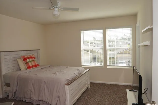a bed sitting in a bedroom next to a window