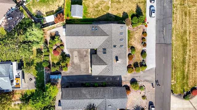 an aerial view of a house with a yard and large trees