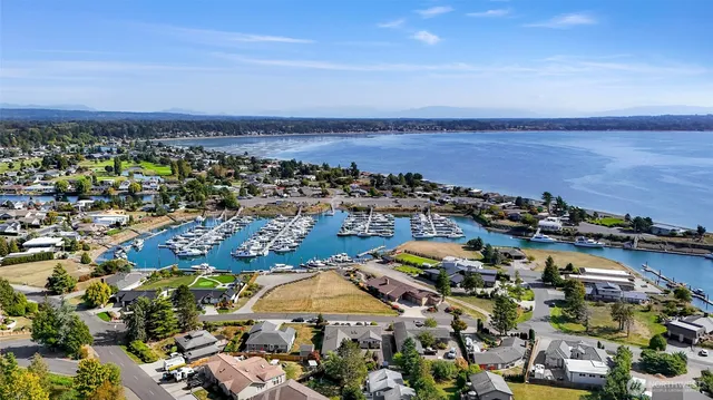 an aerial view of a city with lots of residential buildings and ocean view in back