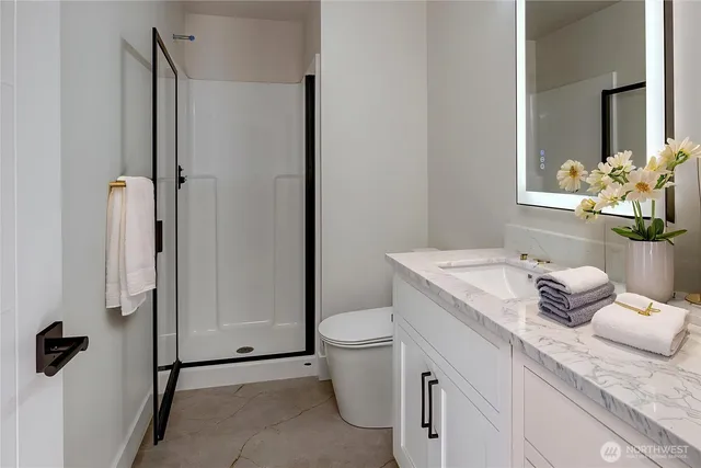 a bathroom with a granite countertop sink toilet and shower