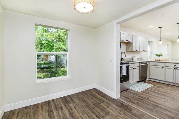 an empty room with wooden floor and a bathroom