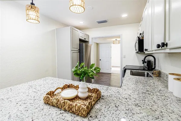 a kitchen with stainless steel appliances granite countertop a sink a stove and cabinets