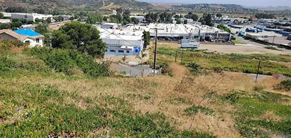an aerial view of residential houses with outdoor space and trees