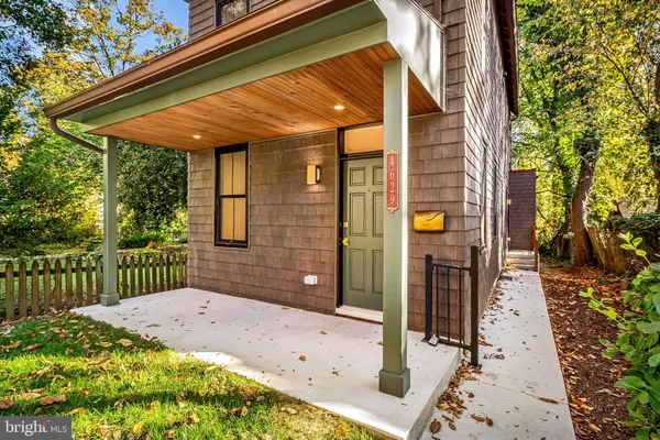 a view of a house with a wooden bench