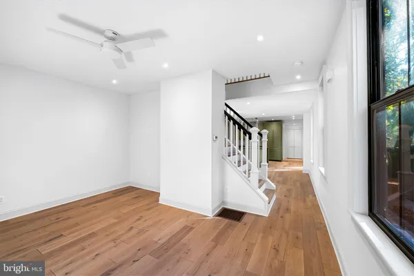 a view of a hallway with wooden floor and staircase