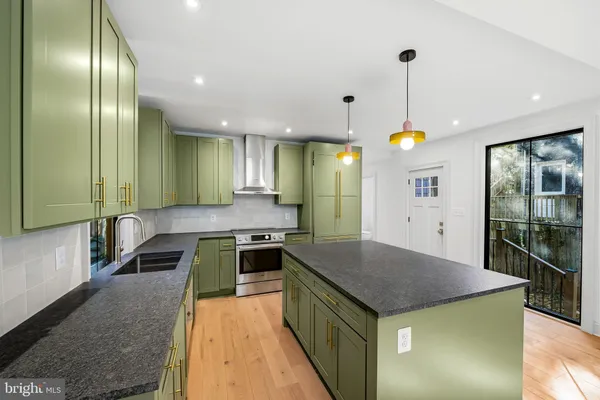 a kitchen with granite countertop stainless steel appliances and wooden floor