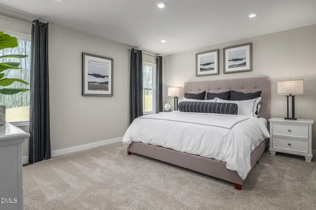 a spacious bedroom with a bed and a lamp