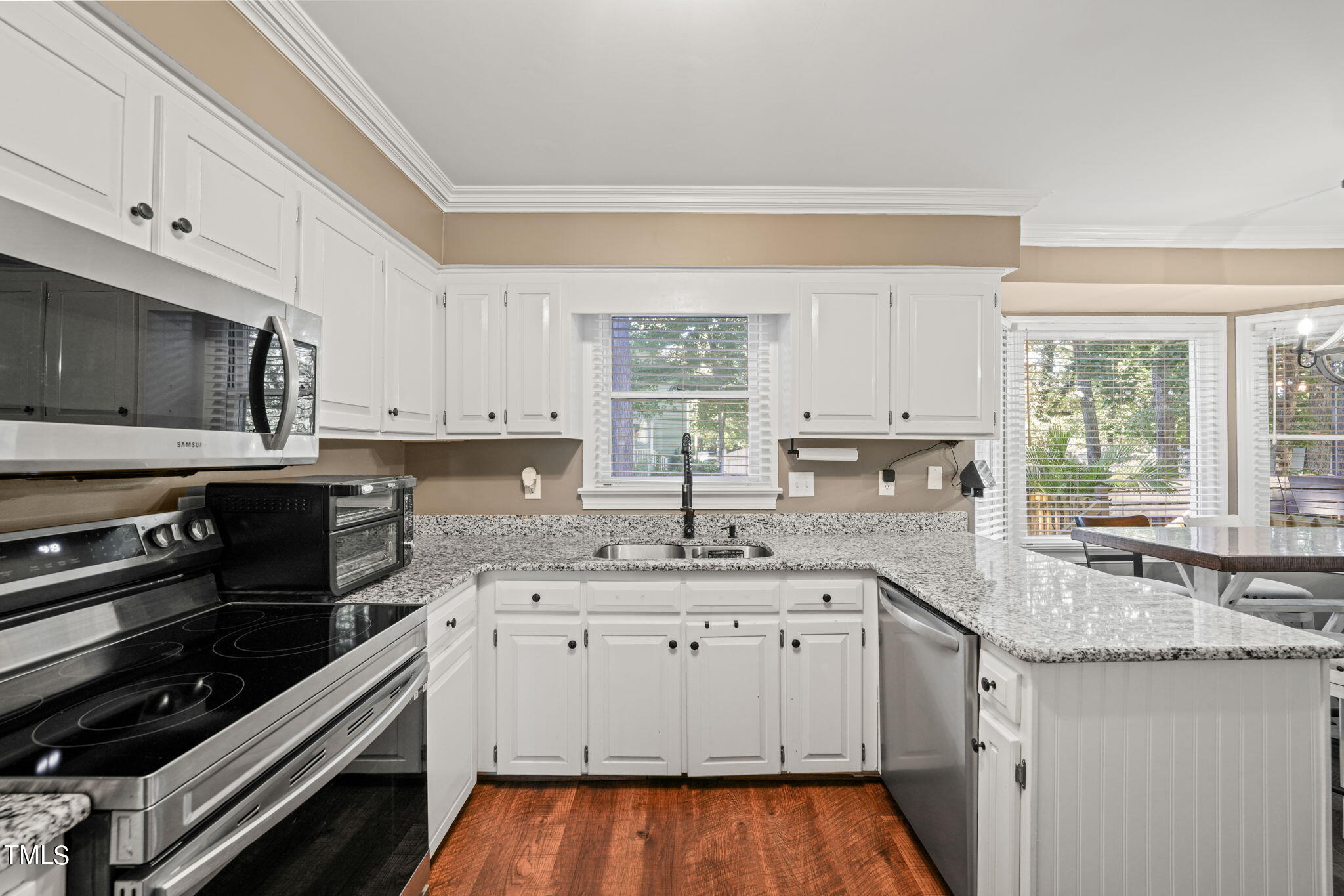 7125 Sandringham Drive Raleigh, NC 27613 - Photo 8 of 26 a kitchen with granite countertop a sink stove and cabinets
