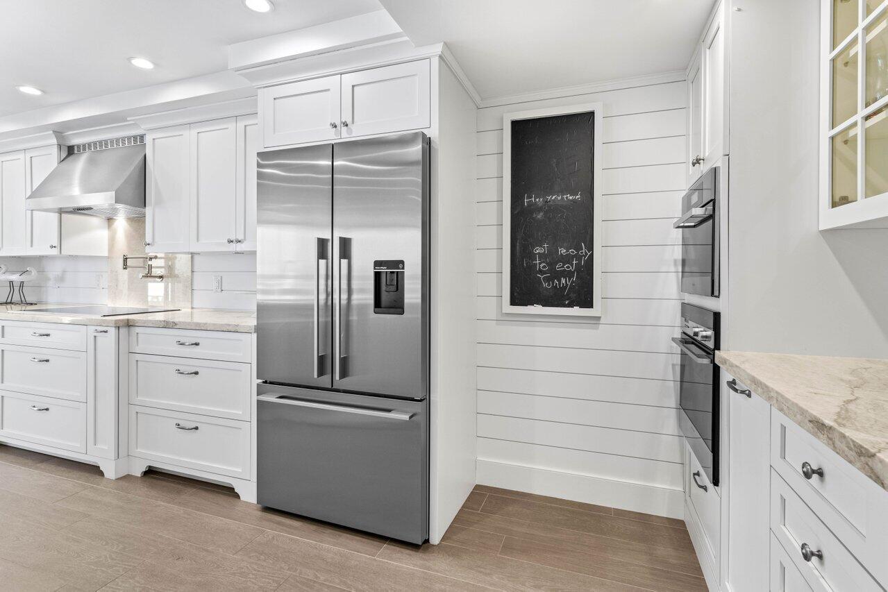 2917 South Ocean Boulevard, Unit 104 Highland Beach, FL 33487 - Photo 33 of 57 a kitchen with white cabinets and white appliances