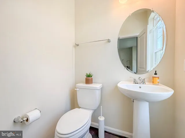 a bathroom with a toilet a sink and mirror