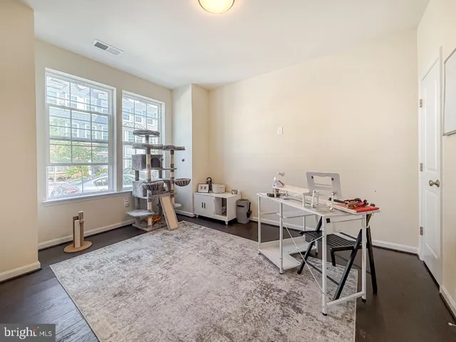 a view of a workspace with furniture and a window