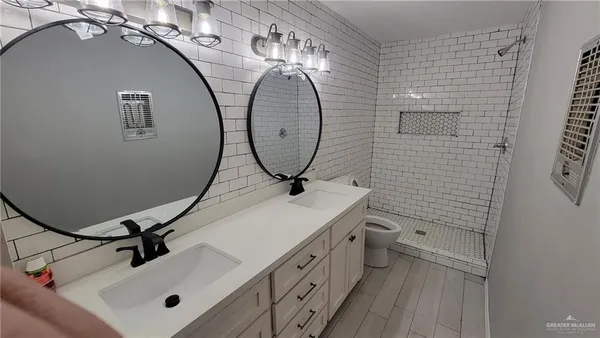 a bathroom with a sink a toilet and a mirror