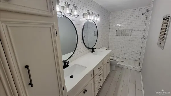 an empty room with chandelier fan and windows