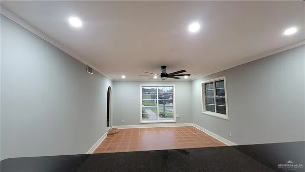 a view of an empty room with a window and wooden floor